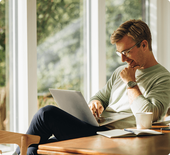 A man with glasses uses a laptop