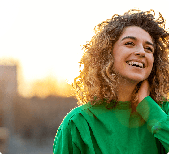 A woman in a green shirt smiles