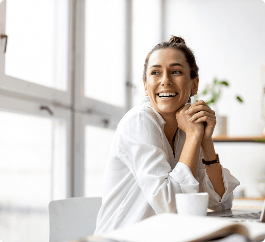 A woman in a white shirt clasps her hands